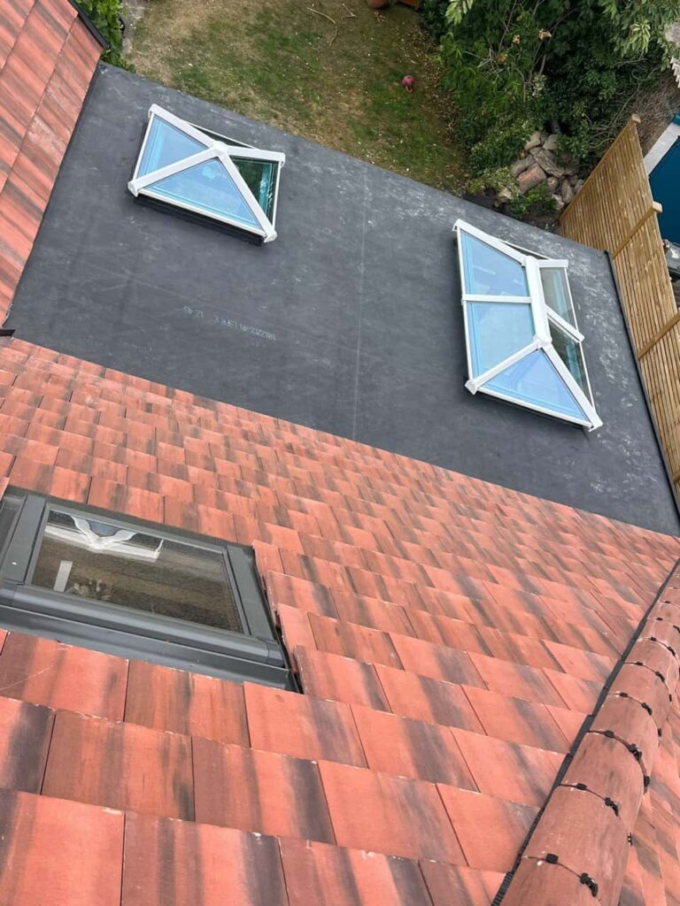 This is a photo taken from the roof ridge looking down a tiled pitched roof on to a flat roof. Works carried out by LS Roofing Thame